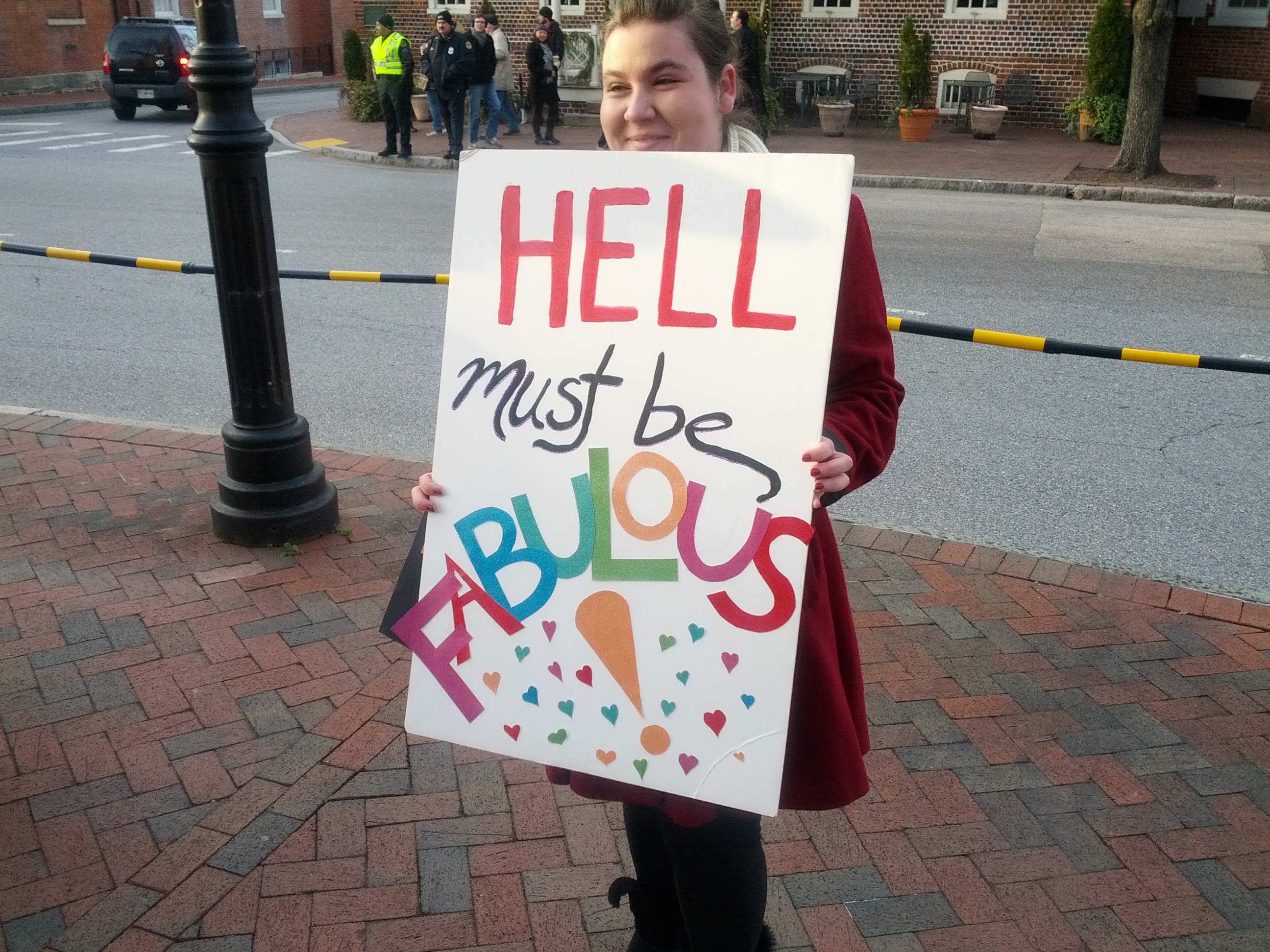 A counter protester holds a sign parodying the message of the Westboro Baptist Church.